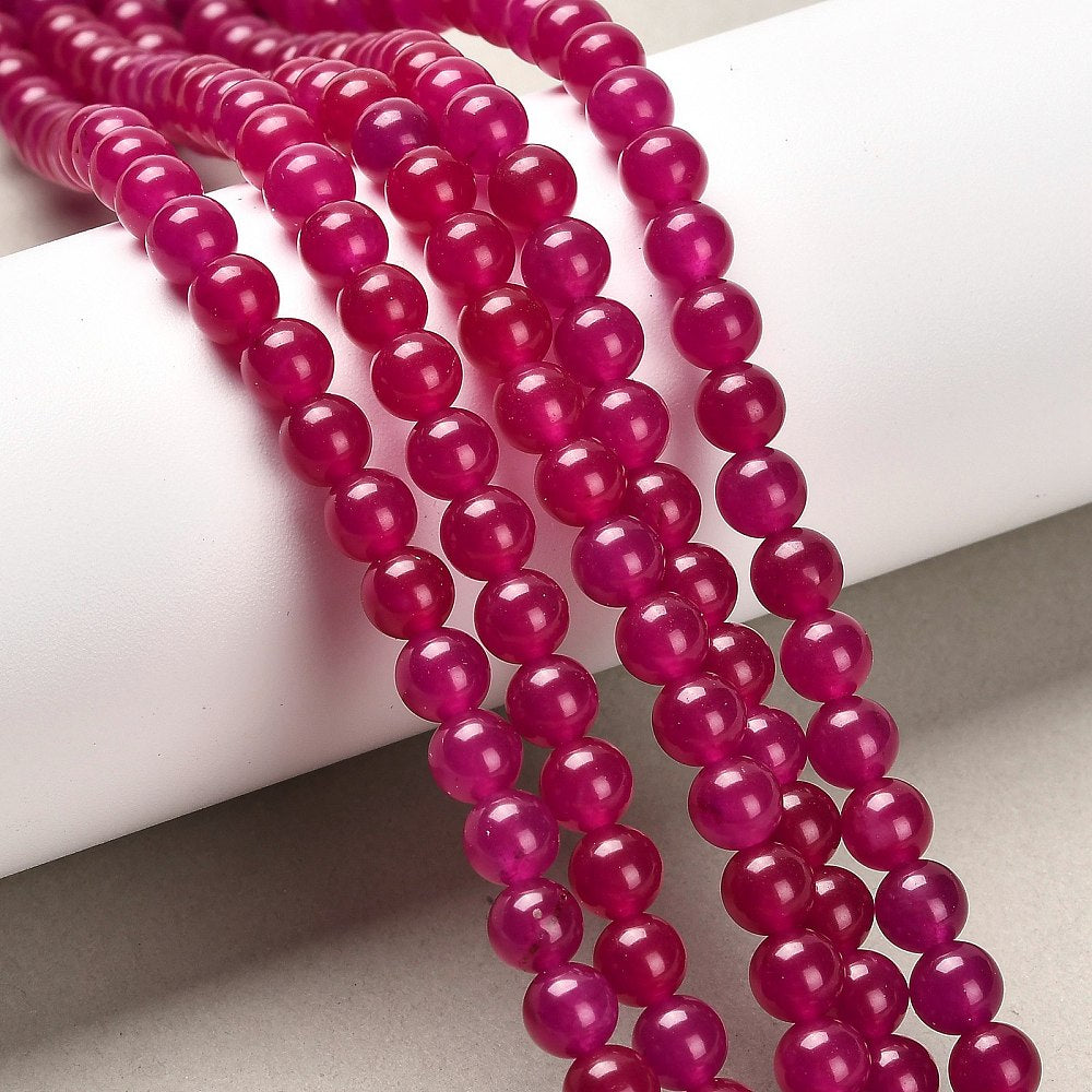 Jade rød violet. Runde 6 mm. Hel streng på ca.  38 cm.